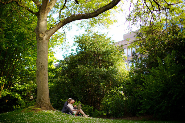 bride and groom sitting under a tree