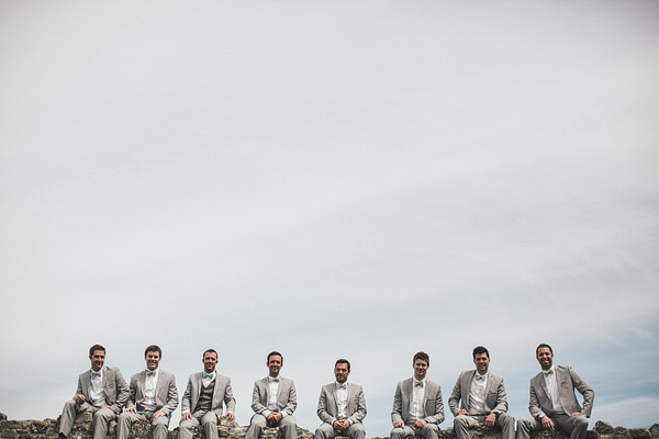 groomsmen sitting on a walll