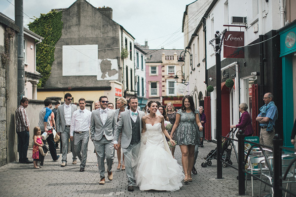 bride and groom walking through village streets