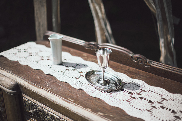 vintage sideboard used as an alter with a white doily tablecloth