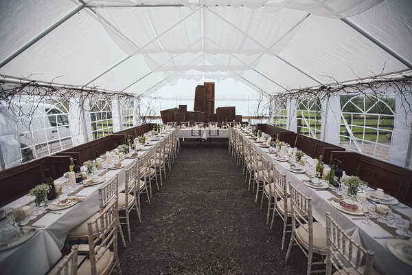 marquee reception with church pews as seating