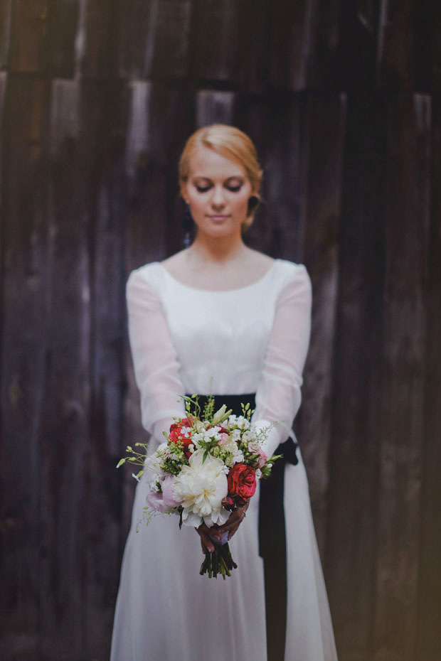 bride with cream and red bouquet