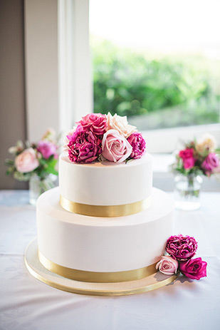 White wedding cake with pink roses | Maria and Mark's pretty in pink and floral wedding by Meridith Lord Photography | onefabday.com