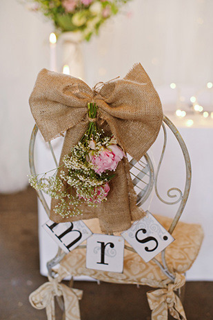 burlap bow wedding chair decor | Grace and Niall's pretty pastel Millhouse wedding by Elisha Clarke | onefabday.com