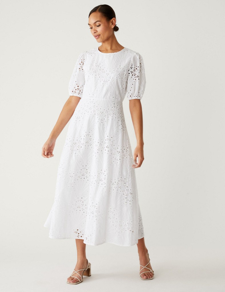 A female model wears a broderie anglaise midaxi dress with white mules