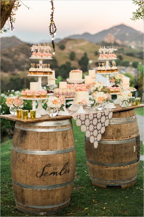 A pink-and-cream dessert bar featuring miniature cakes and cupcakes by Ditzie Cakes sits on top of repurposed wooden barrels // onefabday.com