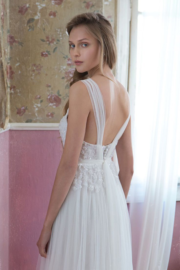 Dress No.7 from Tali Handel wedding dresses 2016 - Slightly pleated skirt with an a-line shirt. Flower tattoo detailing is draped down the back of the dress. Tulle straps and button detailing-  see the rest of the collection on onefabday.com