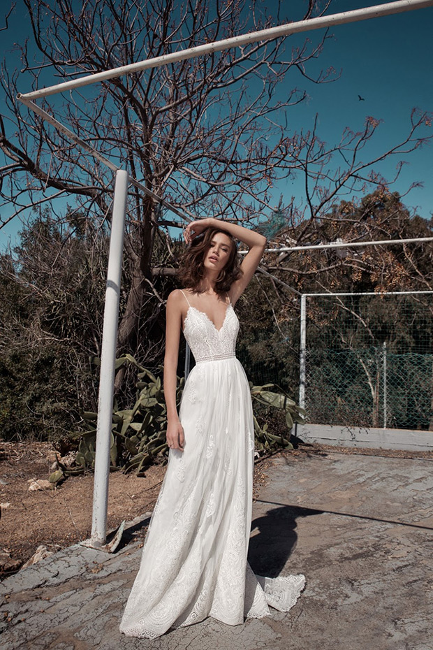 Manuella from Flora wedding dresses 2018 - V-neck line with shoe string straps. Bodice with detailed lace and embroidery. Natural waist line with a layered chiffon skirt, floral detailing throughout.-  see the rest of the collection on onefabday.com