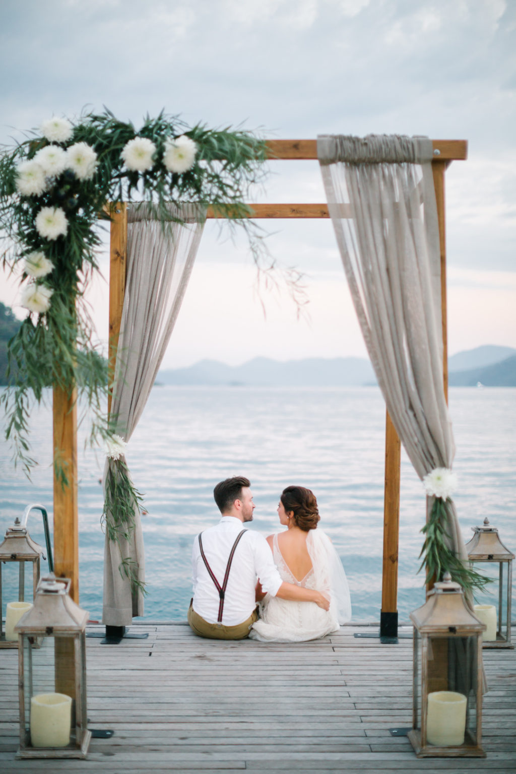 outdoor seaside wedding ceremony, canopy, floral arch, draped fabric