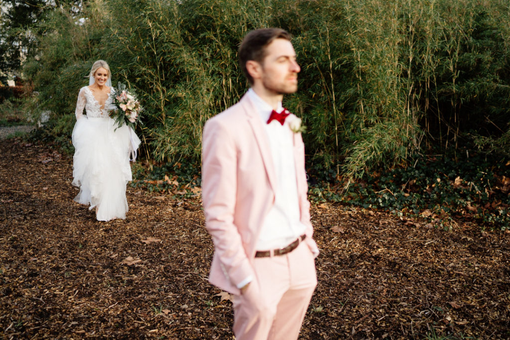 pink groom suit, colourful groom style, Anna Geogina wedding dress, long sleeve wedding dress, lace wedding dress