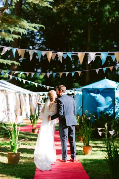 Couple kiss bride groom red carpet exterior ceremony shot