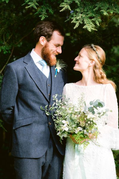 Bride groom looking at each other couple exterior bouquet flowers