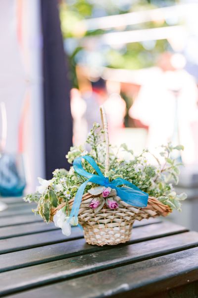 Flower whicker basket blue ribbon on table roses