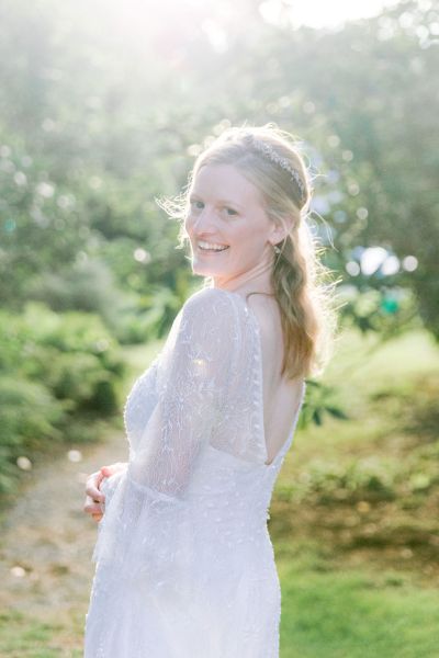 Bride all smiles smiling over the shoulder sunlight sunshine