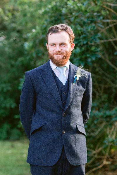 Groom smiling suit exterior flower detail