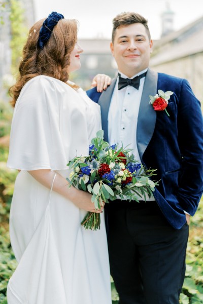 Bride and groom holding bouquet of flowers exterior shot