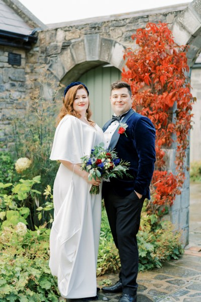 Bride and groom holding bouquet of flowers exterior shot