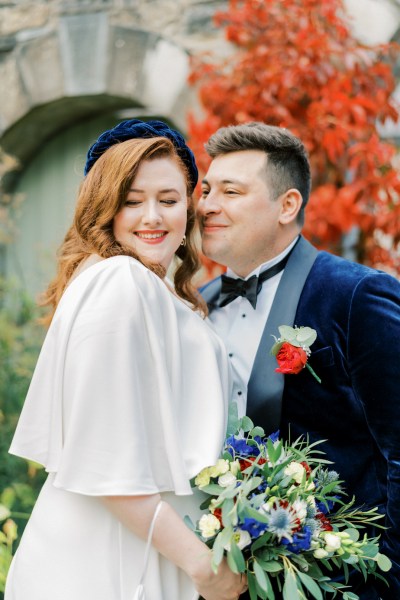 Bride and groom holding bouquet of flowers exterior shot