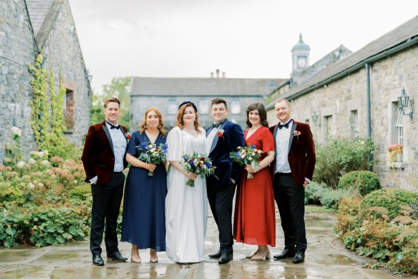 Bride groom family groomsmen bridesmaids bouquet of flowers laughing smiling