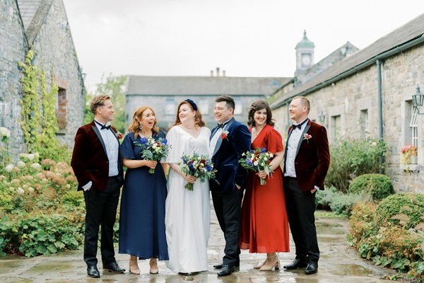 Bride groom family groomsmen bridesmaids bouquet of flowers laughing