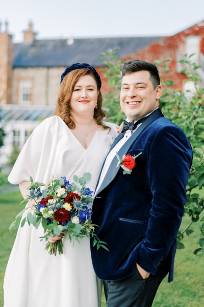 Bride and groom bouquet of flowers exterior looking to camera smiling