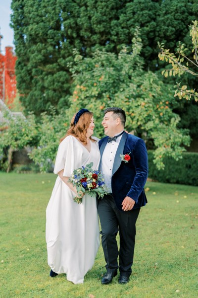 Bride and groom bouquet of flowers exterior grass forest park laughing