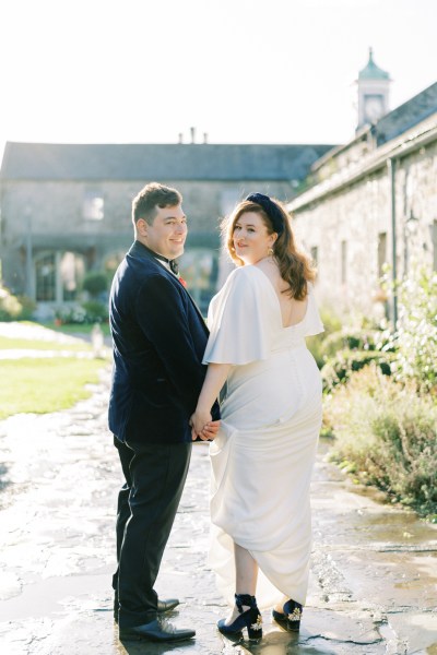 Bride and groom exterior looking over shoulder