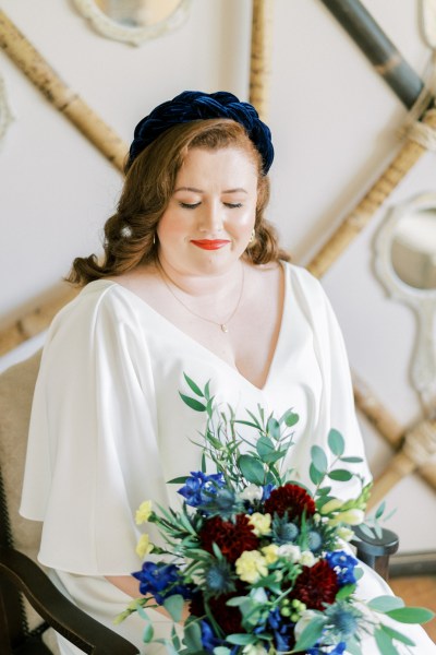 Close up of bride holding bouquet of flowers roses looking down interior