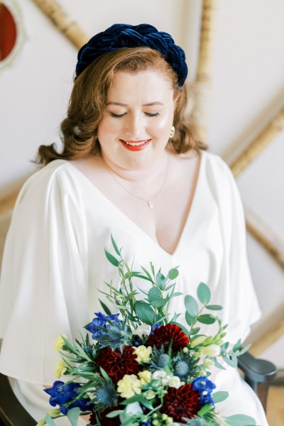 Close up of bride holding bouquet of flowers roses looking down interior