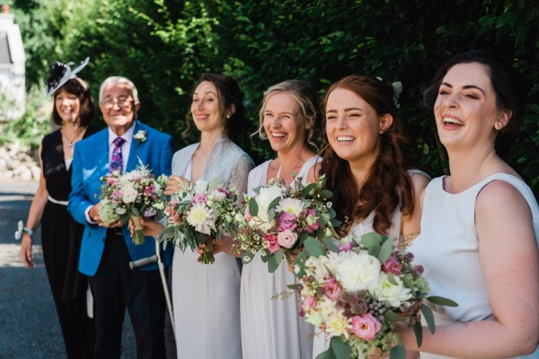 Wedding photography Jane & Alex bridesmaids smiling laughing flowers exterior shot