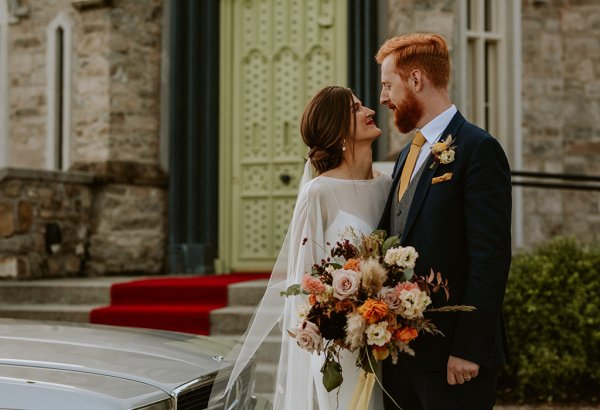 bride and groom laughing at castle outdoors