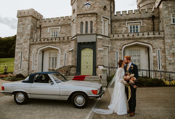 bride and groom laughing at castle outdoors