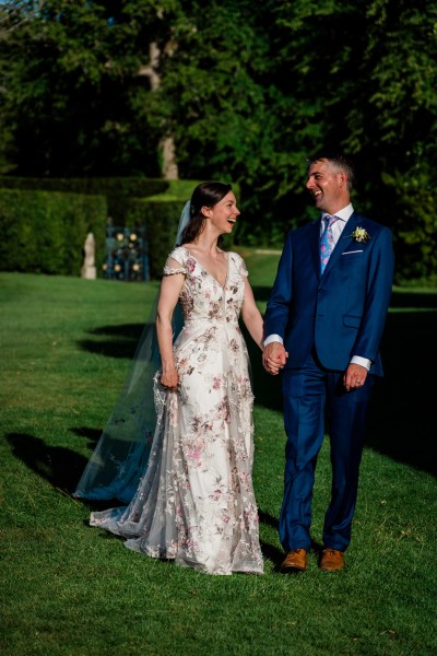 Wedding photography Jane & Alex couple holding hands exterior park gate sunshine summer dress detail