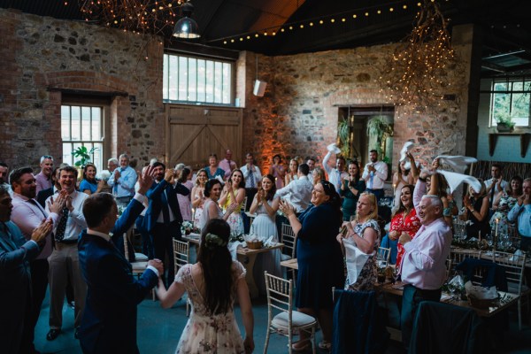 Wedding photography Jane & Alex interior dining guests family eating drinking clapping bride groom