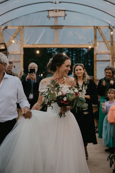 Aisling & Forbes Real Wedding bride smiling phone guests flowers