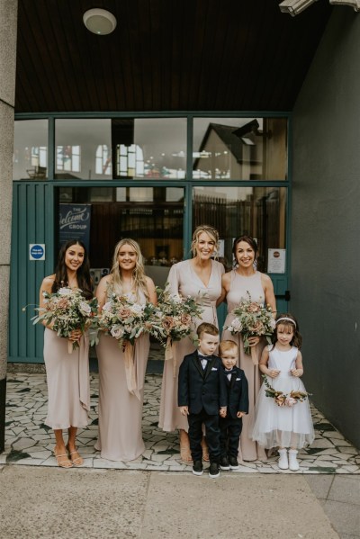 Flower girl bouquet of flowers bridesmaids maid of honour friend exterior shot children smiling