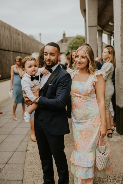 Couple baby guests friends groomsman exterior shot