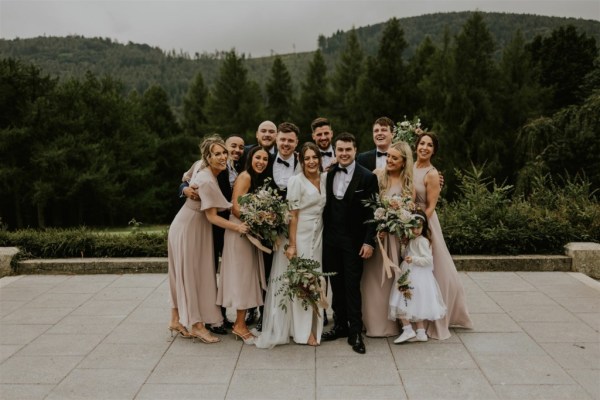 Group photo child exterior mountain forest in background bride groom smiling bridesmaid groomsmen bride groom