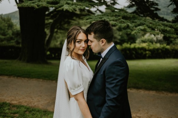 Bride and groom looking to camera park shot exterior veil