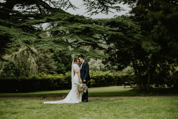 Exterior photography of bride and groom in forest/park holding bouquet of flowers