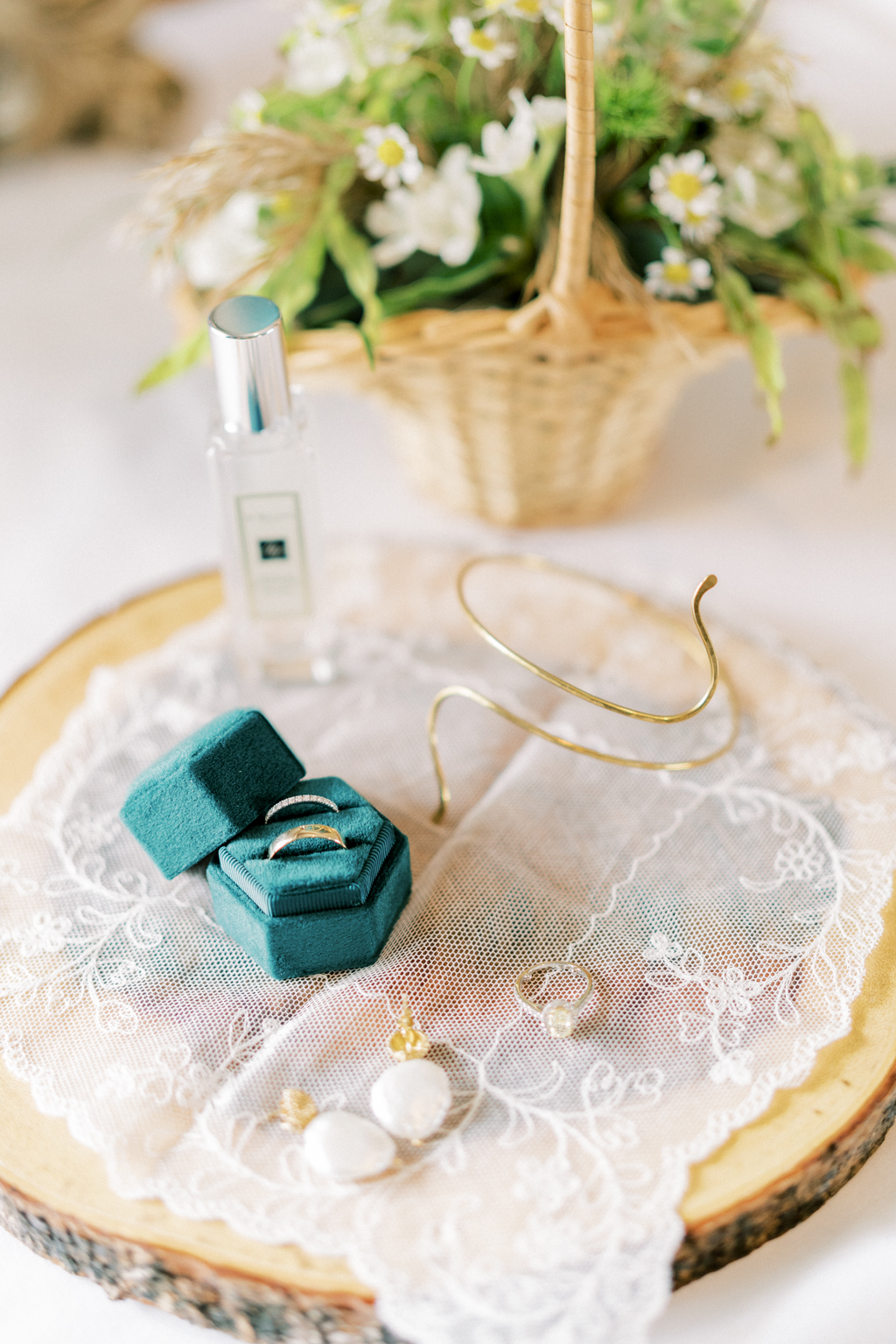 Wedding bands in blue box on tray with bottle of Jo Malone perfume scent