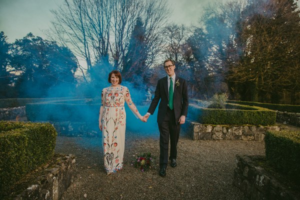 Bride and groom exterior bouquet of flowers exterior garden holding hands blue hue photography smoke