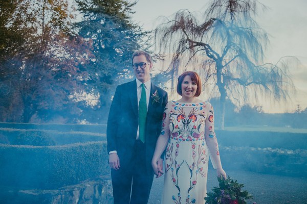 Bride and groom exterior bouquet of flowers exterior garden holding hands blue hue photography smoke