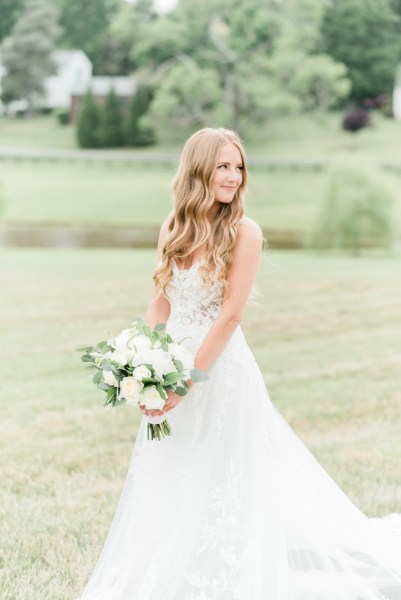 Bride bridal shot lace dress exterior farm holding bouquet of flowers