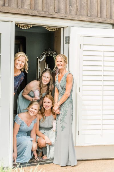 Bridesmaids peeping peeking out of door sunshine sunny guests getting ready