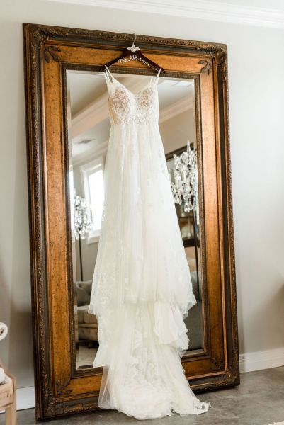 Close up of lace dress hanging up on mirror mr & mrs chandelier elegant shot chair