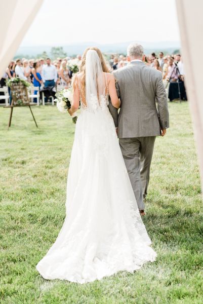 Father of the bride walking down aisle holding bouquet of flowers guests happy smiling clapping