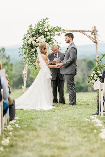 Bride and groom at the alter exterior wedding shot officiant officiate celebration guests