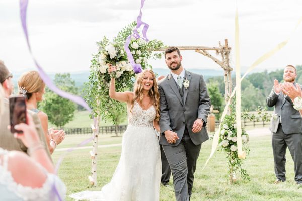 Bride and groom walking down the aisle just wed just married guests clapping ribbon camera phone