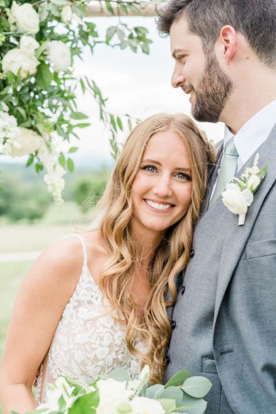 Bride and groom smiling exterior flowers shot bouquet